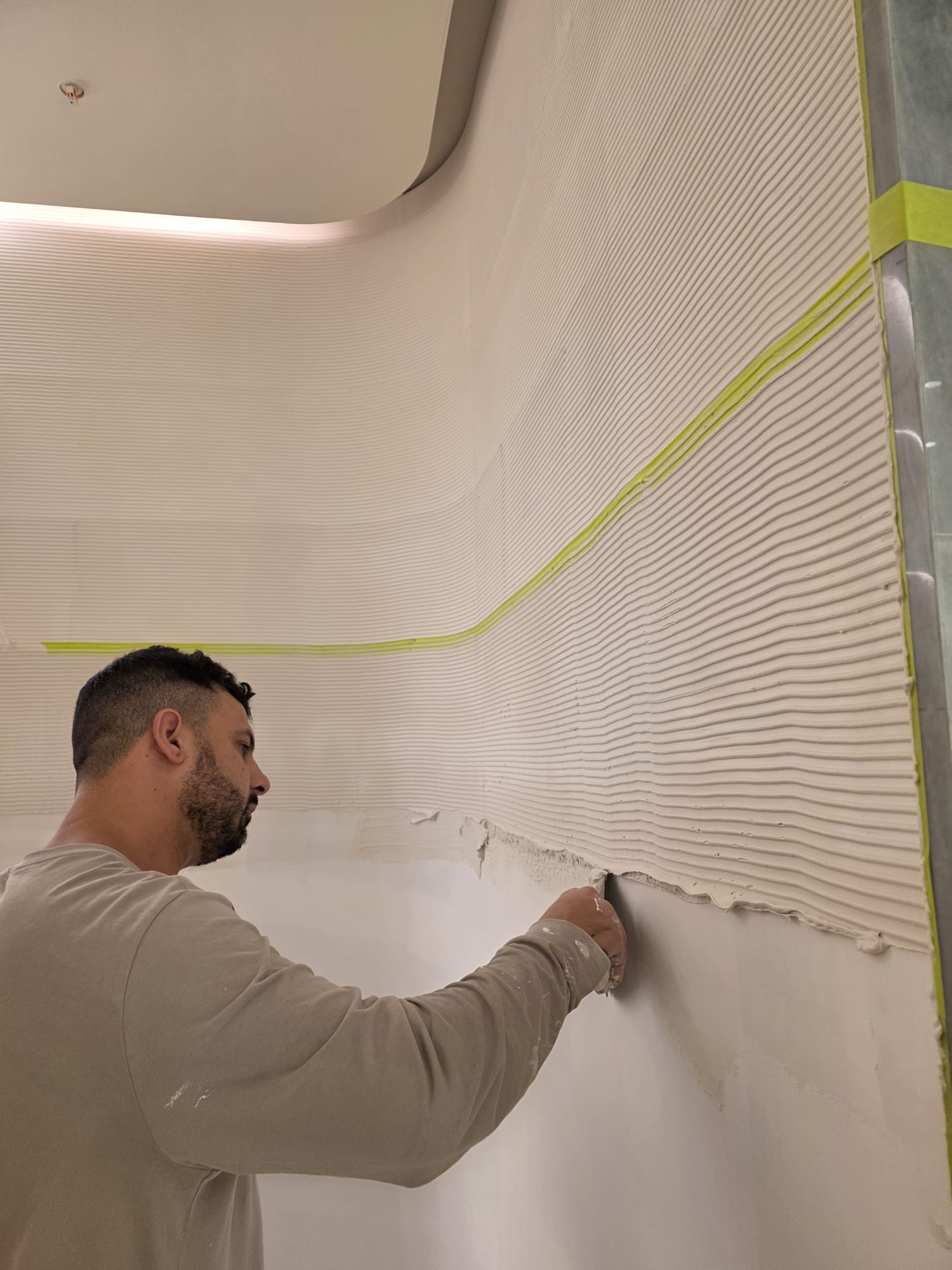 Giovanni Dori trowelling a ribbed custom plaster finish onto a curved wall
