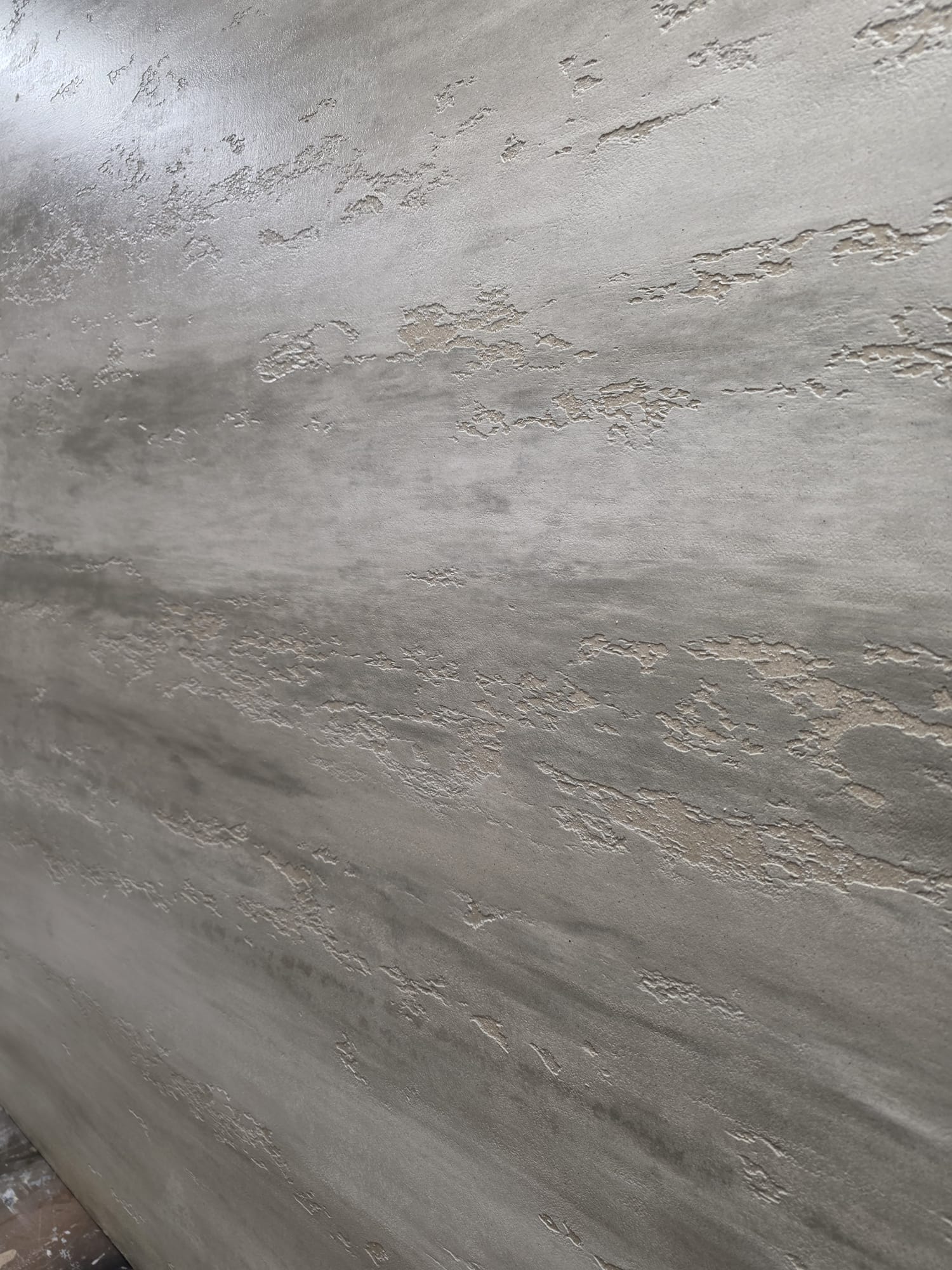 Travertine-effect plaster wall with carved texture
